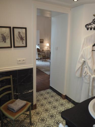 a bathroom with a sink and a chair in a room at Le Quatre in Rennes