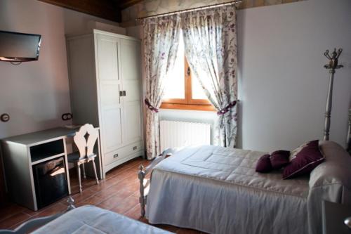 a bedroom with a bed and a window at Hotel La Parra in Aliaga