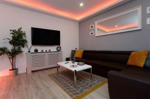 sala de estar con sofá y TV en TOWLER HOUSE APARTMENTS 6 beds in 3 bedrooms en Leeds
