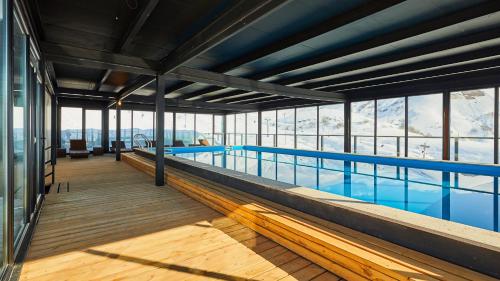 a large swimming pool in a building with windows at Gudauri Loft Hotel in Gudauri