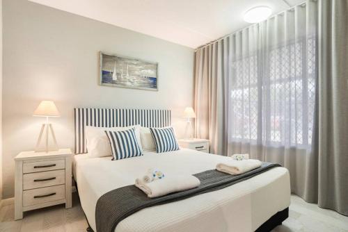 a bedroom with a large bed with towels on it at A cozy Palm Cove unit 3 with a private garden in Palm Cove