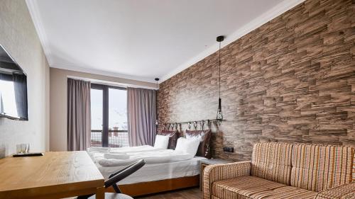 a bedroom with a bed and a stone wall at Gudauri Loft Hotel in Gudauri