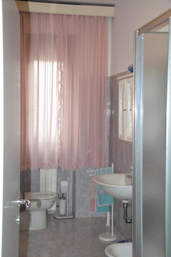 uma casa de banho com 2 lavatórios, um WC e um chuveiro em camera la fortezza em San Piero a Sieve