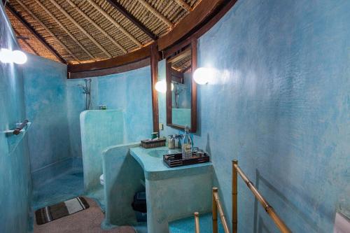 a blue bathroom with a sink and a mirror at Sanghyang Bay Villas in Nusa Lembongan