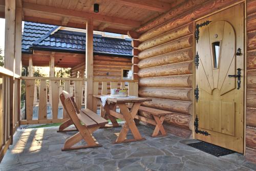 a wooden cabin with a table and a door at HRYCÓWKA Domki z Widokiem in Grywałd
