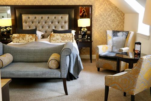 a hotel room with a bed and two chairs at The Old Mill Inn in Pitlochry