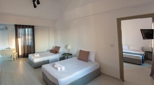 a hotel room with two beds and a mirror at KINGS SQUARE Holiday Apartments in Polis Chrysochous