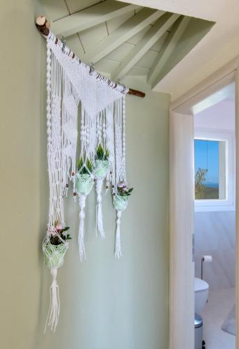 a room with potted plants hanging from a ceiling at Villa Agnanti in Vlachopoulátika