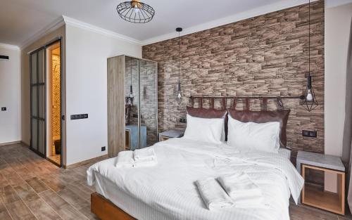 a bedroom with a large bed and a brick wall at Gudauri Loft Hotel in Gudauri