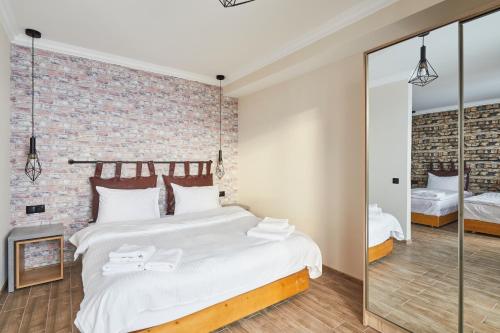 a bedroom with a large bed and a brick wall at Gudauri Loft Hotel in Gudauri