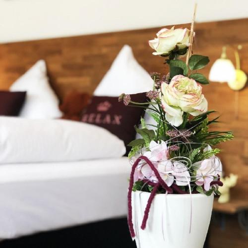 a potted plant with roses in a bedroom at MoselUnion - "schlafen & genießen" in Cochem