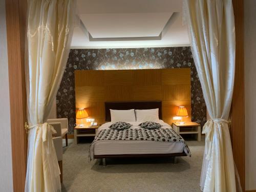 sypialnia z łóżkiem z dwoma stołami i dwoma lampami w obiekcie Grand Nur Plaza Hotel w mieście Aktau