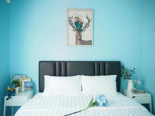 a bedroom with a bed with a blue wall at Makkasan Happy Home in Bangkok