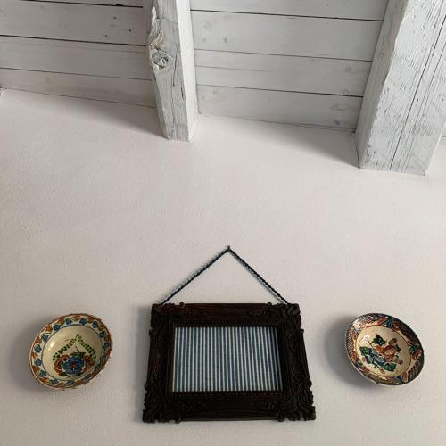 two plates are hanging on a wall with a mirror at La Peschiera B&B in San Lorenzo del Vallo