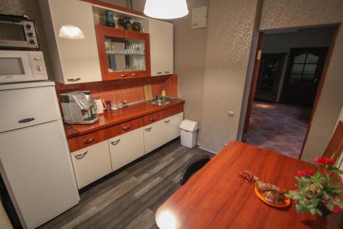 a kitchen with a wooden table and a counter top at Muzeja apartamenti in Riga