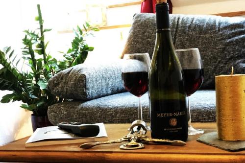 a bottle of wine and two glasses on a table at MoselUnion - "schlafen & genießen" in Cochem