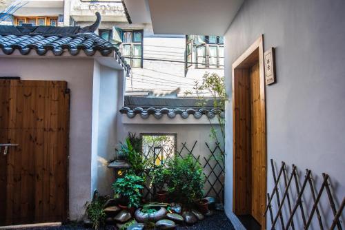 an external view of a house with a door and plants at BaHaoBieYuan in Fenghuang