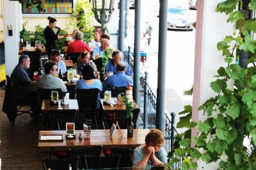 a group of people sitting at tables in a restaurant at MoselUnion - "schlafen & genießen" in Cochem