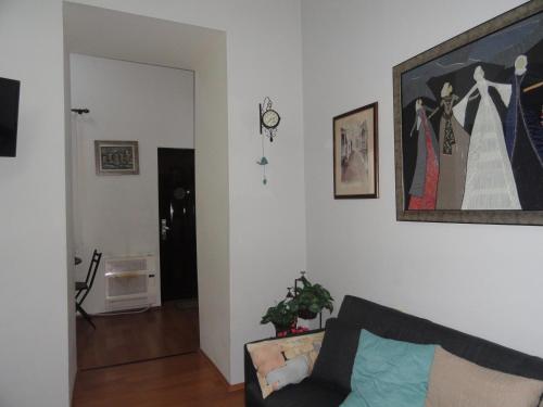 a living room with a couch and a picture on the wall at Apartment Fine Home in Tbilisi City