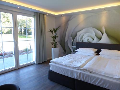 - une chambre avec un grand lit et une grande fenêtre dans l'établissement Landhaus Wörpedorf, à Grasberg
