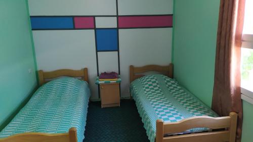 two twin beds in a room with two windows at EDEM SEVAN in Sevan