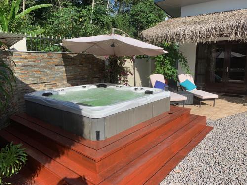 einen Whirlpool mit Sonnenschirm auf einer Terrasse in der Unterkunft Liberdada Suites in Wanica