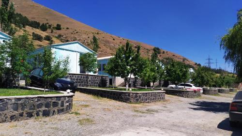 a house with a stone retaining wall next to a mountain at EDEM SEVAN in Sevan