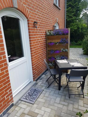 a patio with a table and chairs next to a door at LA RIVIERE DU BIEN ETRE in Chaumont-Gistoux