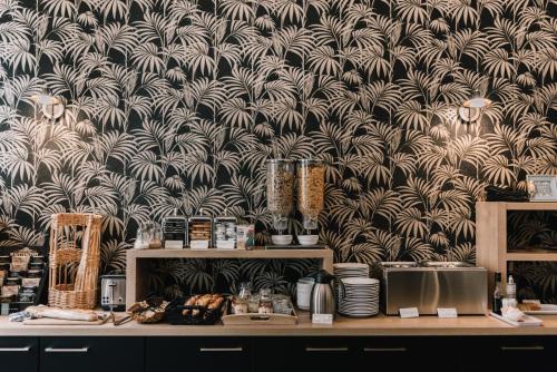 a wall with a black and white wallpaper at Hôtel La Résidence in Narbonne