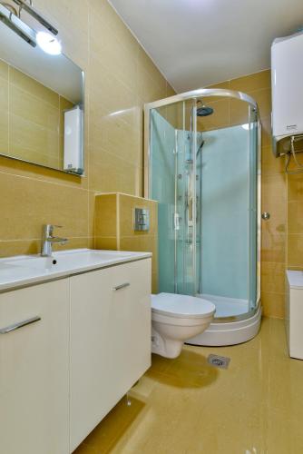 a bathroom with a toilet and a glass shower at Lux Apartman Sofia in Sveti Stefan