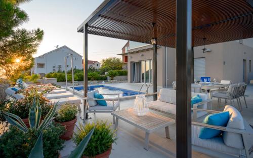 un patio con mesa, sillas y piscina en Villa Moderna Family Friendly, en Hvar
