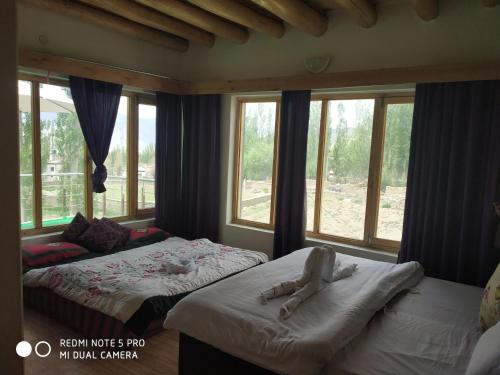 a bedroom with two beds with people laying on them at Morning Sky Guest House in Leh