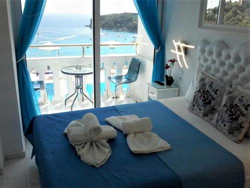 a bedroom with a blue bed and a view of the ocean at Andreas Kanali in Parga