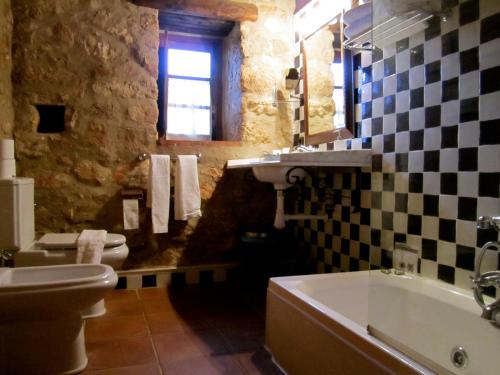 a bathroom with a sink and a tub and a toilet at Apartamentos Rurales La Macera **** in Valencia de Alcántara
