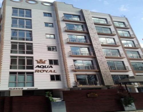 a tall building with aania royal sign on it at Aqua Royal Alexus Luxury Holiday Apartments Girne in Kérynia