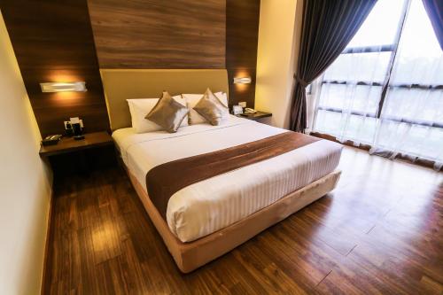 
a white bed with a white comforter and pillows at Sunway Lost World Hotel in Ipoh
