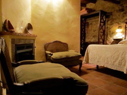 a living room with two beds and a fireplace at Apartamentos Rurales La Macera **** in Valencia de Alcántara