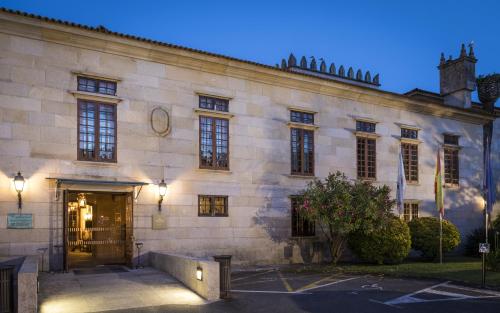 a large stone building with a door and lights at Parador de Cambados in Cambados
