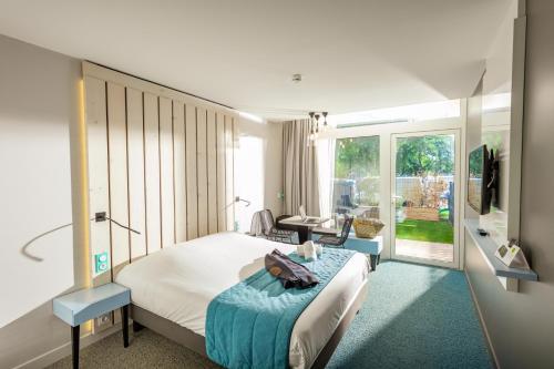 une chambre d'hôtel avec un lit et un salon dans l'établissement Opéralia Hôtel les Pins, à Balaruc-les-Bains