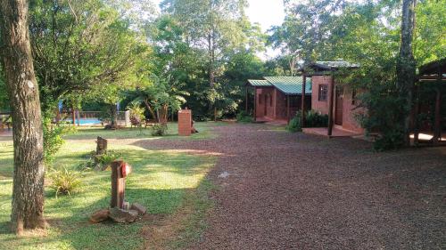 un parque con un edificio y un patio con árboles en Estrella del Monte en Puerto Iguazú