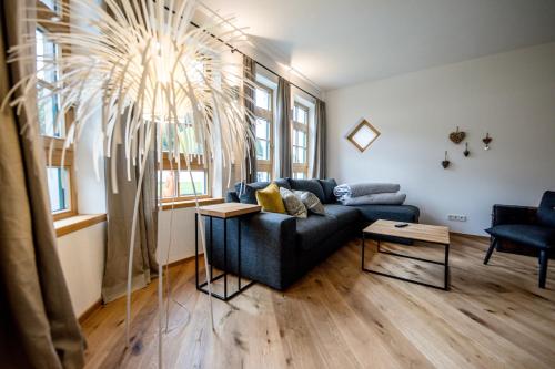 a living room with a couch and a palm tree at Leni´s Appartements in Fieberbrunn