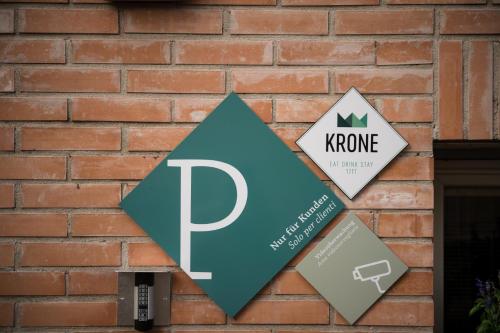 a street sign on the side of a brick building at KRONE eat drink stay in Bressanone