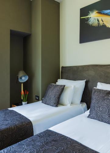two beds sitting next to each other in a room at Kalvin Boutique Hotel by Levinsky Market Tel-Aviv in Tel Aviv