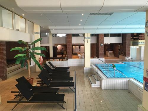 a lobby with a pool and chairs and a swimming pool at Ferienwohnung Reinhold in Sankt Englmar