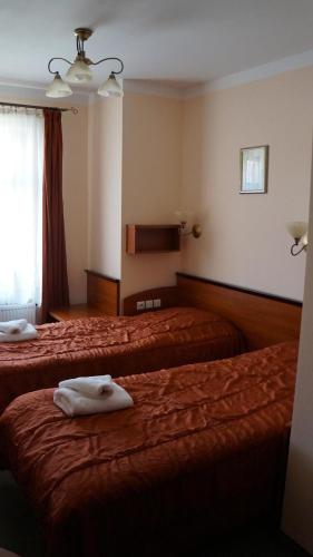 a hotel room with two beds with towels on them at Hotel Leliwa in Leśna
