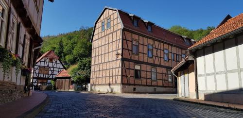 a large brick building on a cobblestone street at Art Apartment - Harz in Stolberg i. Harz