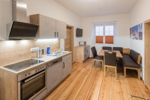 a kitchen with a table and a dining room at Ferienwohnungen Appartementhaus Hohe Tauern in Obervellach
