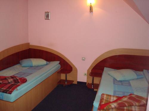 a room with two beds in a room with a wall at Pensiunea Marc in Suceava