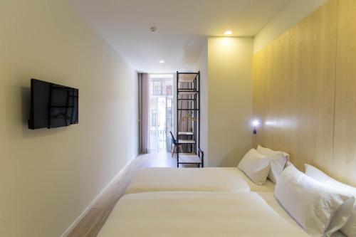 a hotel room with two beds and a television at The Gate in Porto