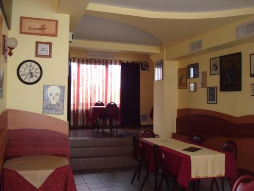 a restaurant with tables and chairs and a clock on the wall at Pensiunea Marc in Suceava